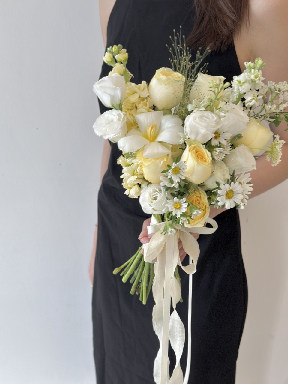 Delicate butter yellow roses combined with white florals and daisy-like blooms – a romantic bouquet perfect for modern brides.