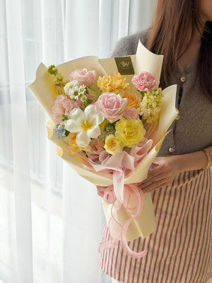 Close-up shot of vibrant mixed floral arrangement with white tulip and satin ribbon.