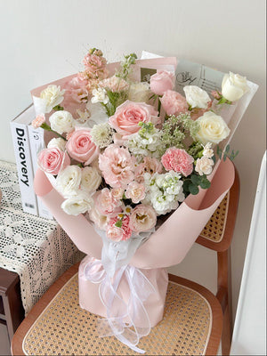 Bouquet of pink and white flowers on a chair with a magazine beside.