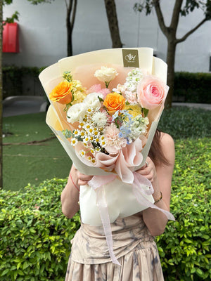 A bright bouquet of flower is holding by a girl in a green background.