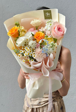 Person holding a bouquet of flowers against a plain background