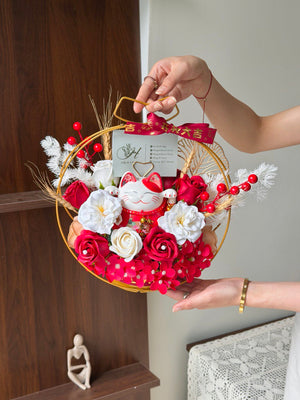 Decorative soap flower arrangement with a cat figurine held by a person against a neutral background this is a gift for business oepning.