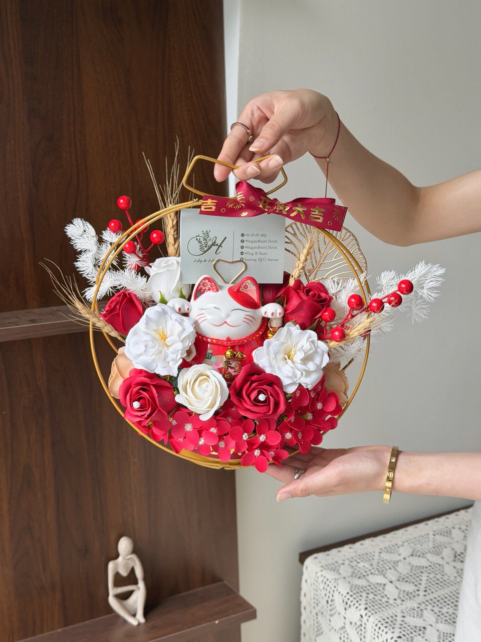 Decorative soap flower arrangement with a cat figurine held by a person against a neutral background this is a gift for business oepning.