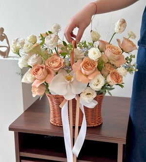 A charming basket of cappuccino roses, white eustoma, and orchids, perfect as a housewarming gift or business opening gesture.