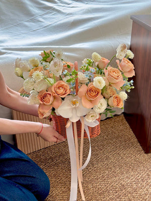A warm-toned floral basket featuring cappuccino roses and delicate white flowers, suitable for home décor or thoughtful gifting.