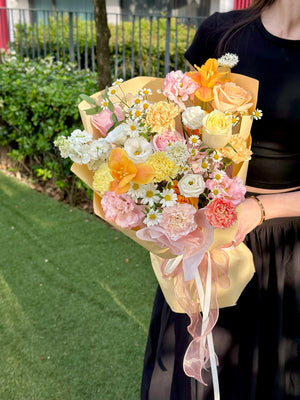 Elegant bouquet wrapped in soft yellow and pink, ideal for celebrations or thoughtful gifts.