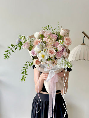 Person holding a bouquet of flowers against a plain background. Perfect for birthday or anniversaries.