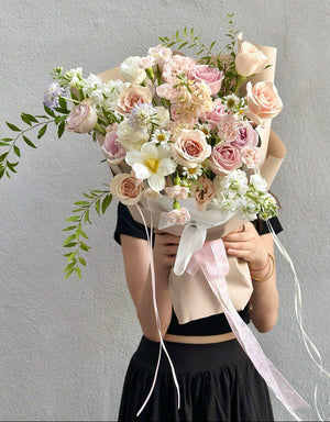 Handcrafted pastel flower bouquet featuring roses, tulip, and delicate foliage.