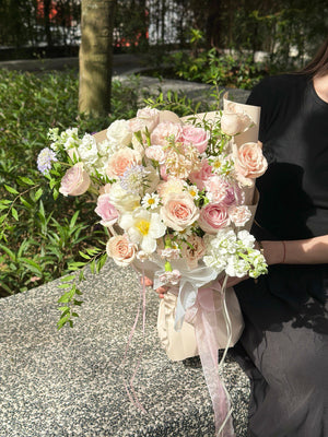 Minimalist Korean-style bouquet with pastel roses and lush green leaves.