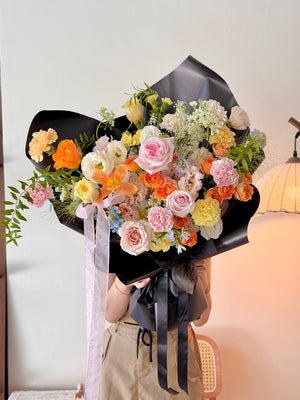 Handcrafted Korean-style bouquet with black wrapping and soft pink ribbon for modern elegance.