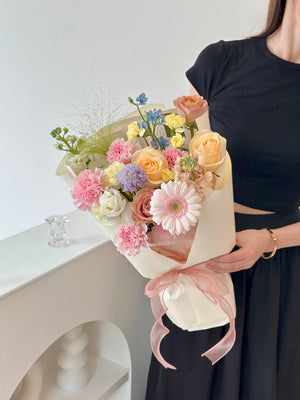 A girl in black holds a bright bouquet of flowers, symbolizing love and appreciation for her mother on Mother's Day 2025.