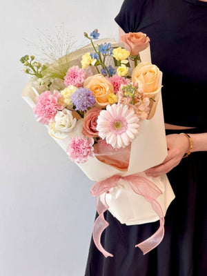 A girl in black holds a vibrant bouquet of flowers, celebrating Mother's Day 2025 with a heartfelt gift for her mother.