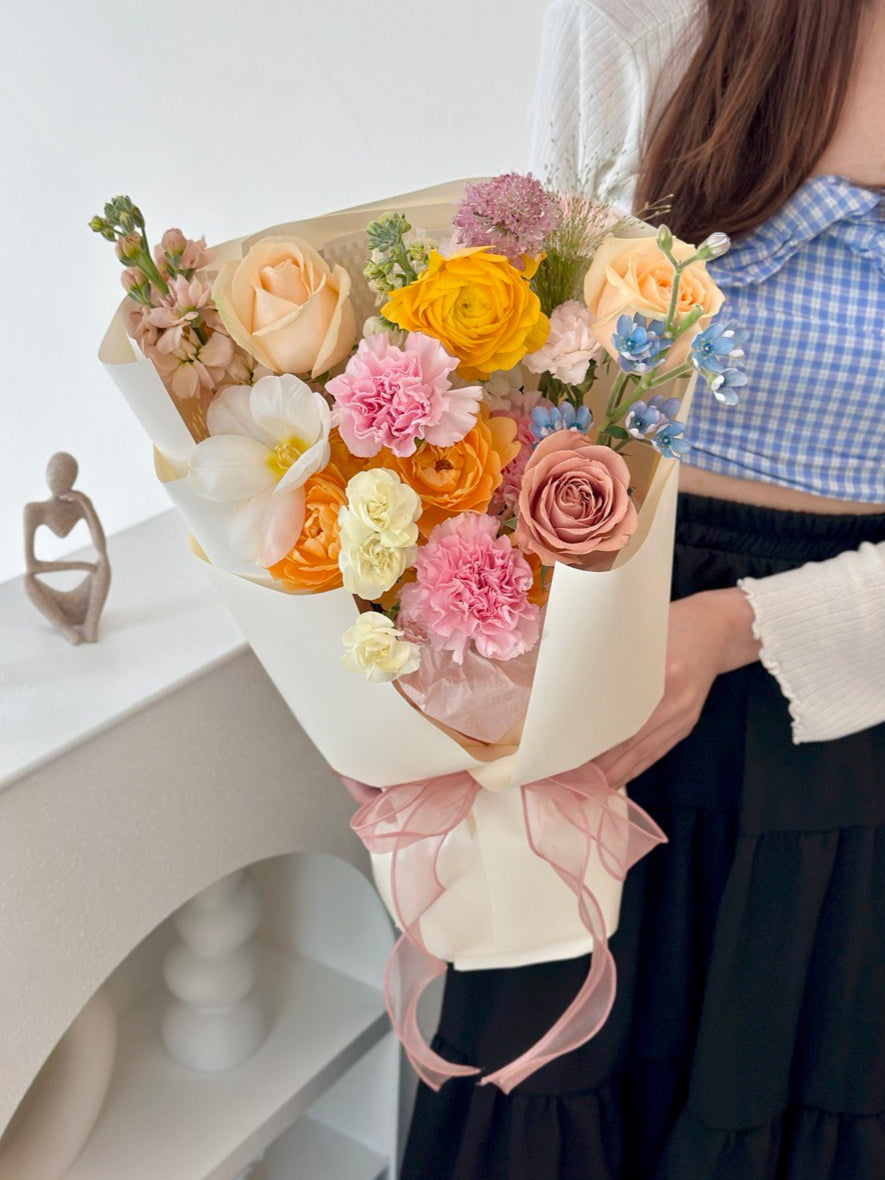 A girl dressed in blue holds a bright bouquet of flowers, celebrating Mother's Day 2025 at Malaysia.