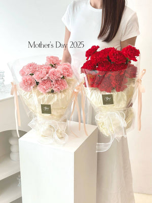A girl in a white top holds pink and red carnation bouquets, celebrating Mother's Day 2025.