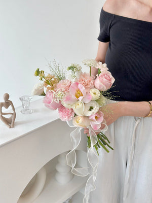 A bride in Malaysia displays a bouquet of pink tulips mixed with white and pink roses on her wedding day.