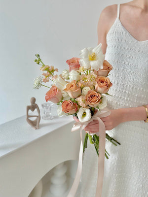 A bride in a white dress holds a bouquet of Cappuccino Roses, captured during her wedding in Kuala Lumpur.
