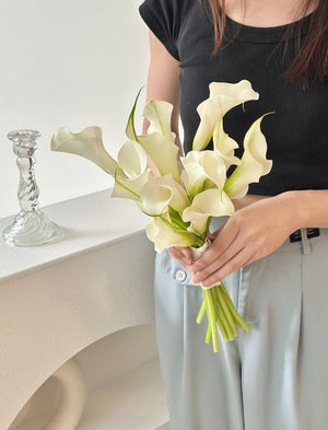 1. A bride holding a bouquet of white calla lilies, symbolizing elegance and purity for her ROM wedding ceremony.
2. A woman in a wedding dress holds a bouquet of white calla lilies, representing grace and beauty for her ROM wedding.
3. A bride proudly displays a bouquet of white calla lilies, chosen for their elegance for her ROM wedding celebration.