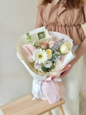 A woman in a brown shirt holds a gerbera bouquet for her friend's birthday in Kuala Lumpur.