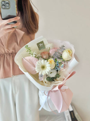 A girl in a brown shirt holds a colorful gerbera bouquet, celebrating her friend's birthday in Kuala Lumpur.