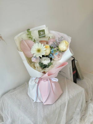 A bouquet of gerbera flowers is placing on top of a box with book at a side in Kuala Lumpur.