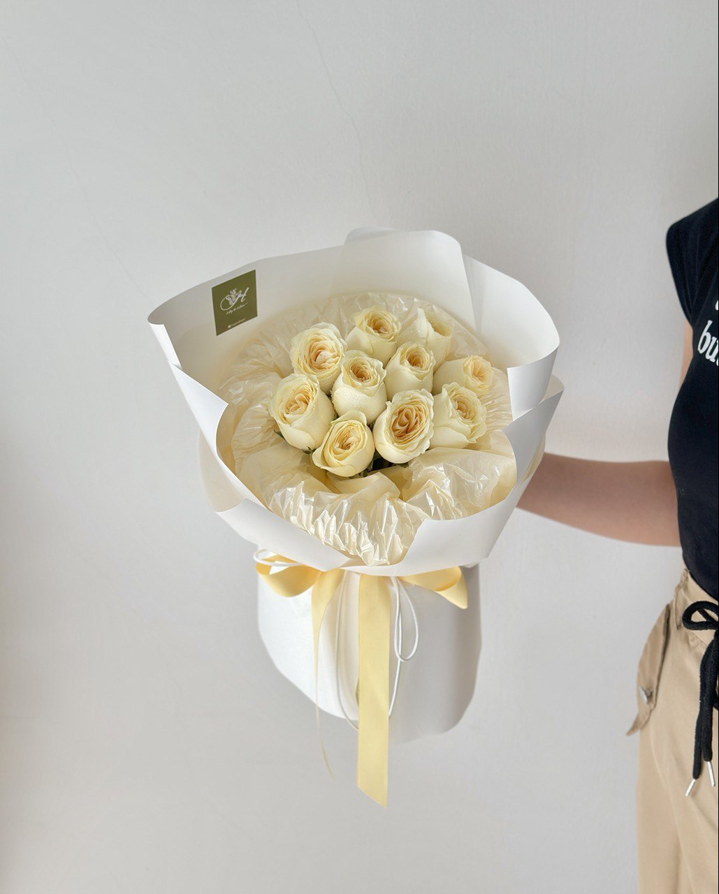 A girl is holding a round bouquet of buttercup roses - same day delivery flower Kuala Lumpur and Selangor, prepared by hug and heart florist subang jaya.
