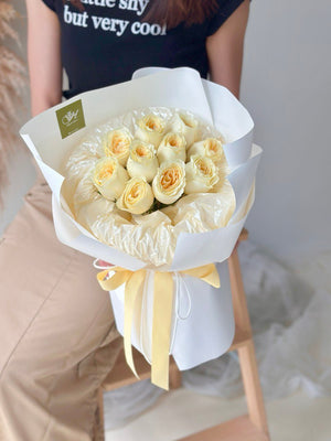 A girl is holding a round bouquet of buttercup roses - same day delivery flower Kuala Lumpur and Selangor, prepared by hug and heart florist subang jaya.