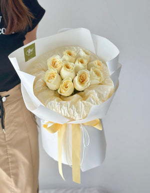 A girl is holding a round bouquet of buttercup roses - same day delivery flower Kuala Lumpur and Selangor, prepared by hug and heart florist subang jaya.