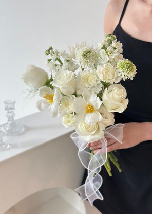 1. A woman in a wedding dress holds a bouquet of white flowers, symbolizing love and celebration.
2. A bride holds a bouquet of white flowers, representing purity and joy on her wedding day.
3. A woman in a wedding gown proudly displays a bouquet of white flowers, embodying elegance and romance.