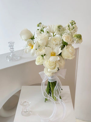 1. A woman in a wedding dress holds a bouquet of white flowers, symbolizing love and celebration.
2. A bride holds a bouquet of white flowers, representing purity and joy on her wedding day.
3. A woman in a wedding gown proudly displays a bouquet of white flowers, embodying elegance and romance.