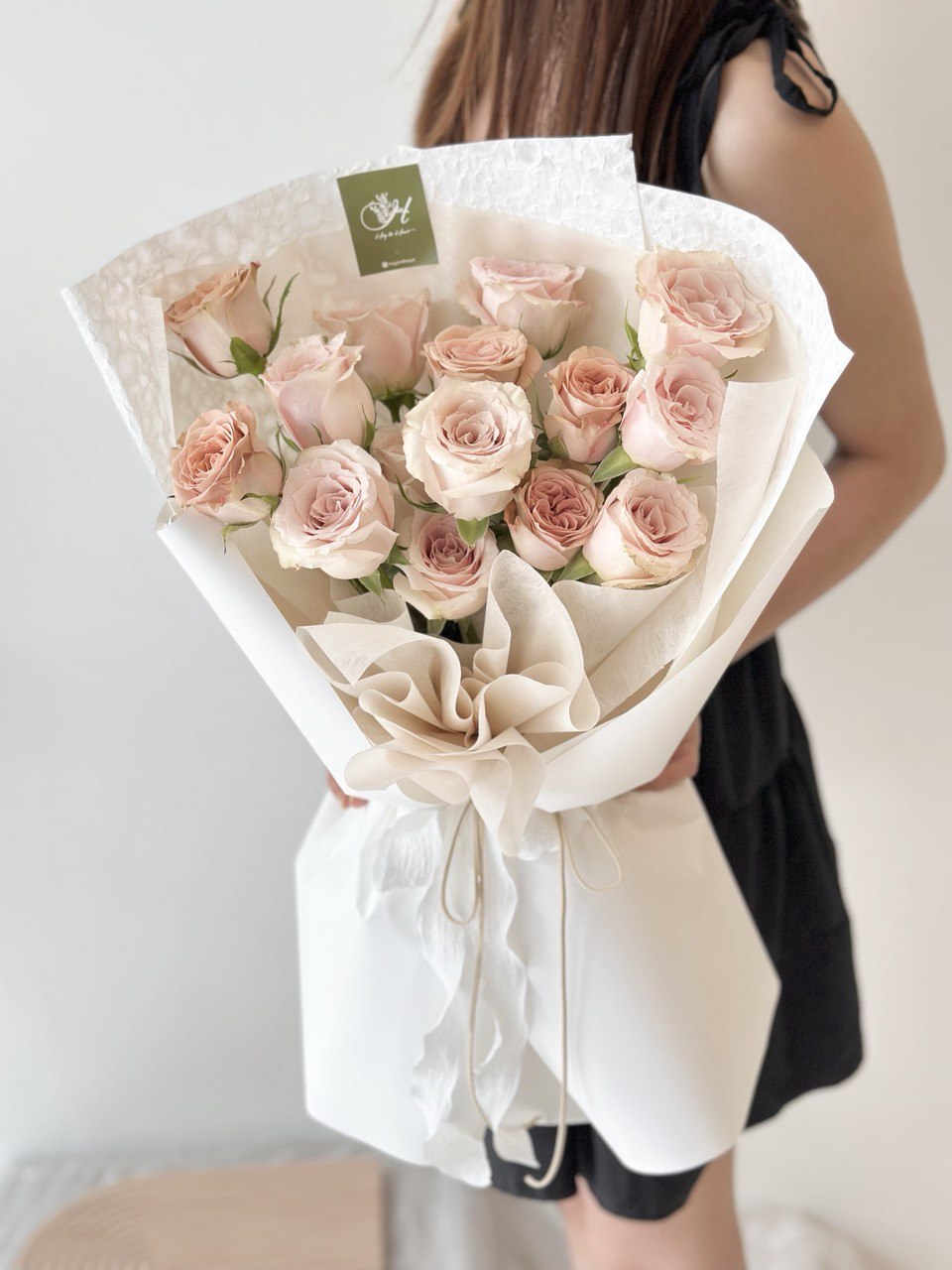 A girl is holding a bouquet of quicksand rose and cappuccino rose with same day delivery at Kuala Lumpur prepared by Hug and Hear Florist Subang Jaya.
