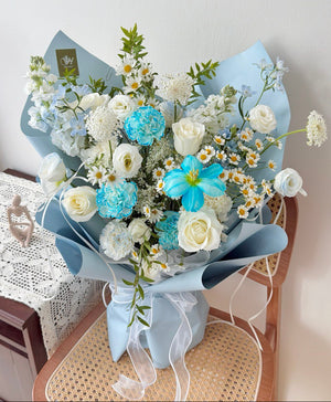Bouquet of flowers with blue tulip and blue carnation and white flowers on a chair, perfect for birthday or anniversaries gift.