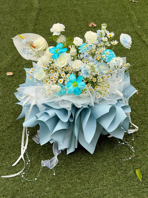 Bouquet of flowers with blue and white flowers on a green surface, perfect for proposal in Malaysia.