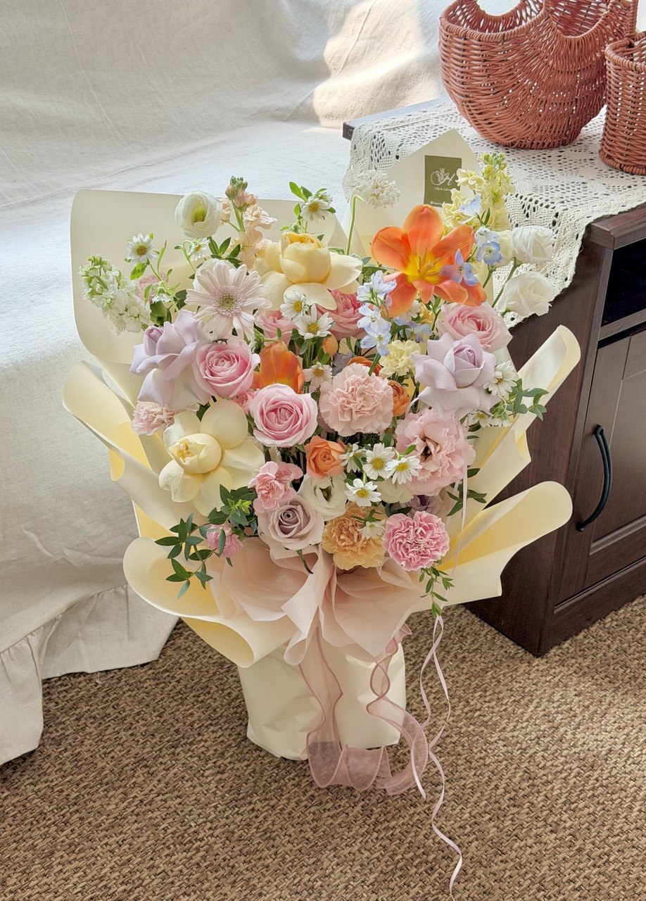 Premium mixed flower bouquet with orange tulips, pink roses, lilac roses and pastel gerbera for birthday gifts.