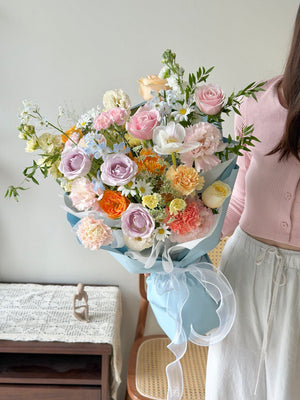 Luxury pastel flower bouquet with roses, carnations and delicate fillers in Korean-style wrapping.