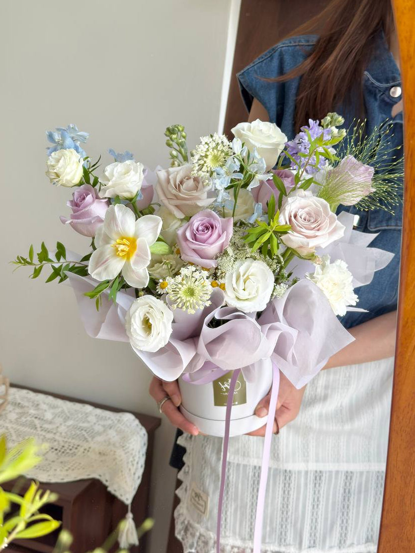 Pastel flower box with lilac roses and white blooms, perfect for housewarming or anniversary gifting.