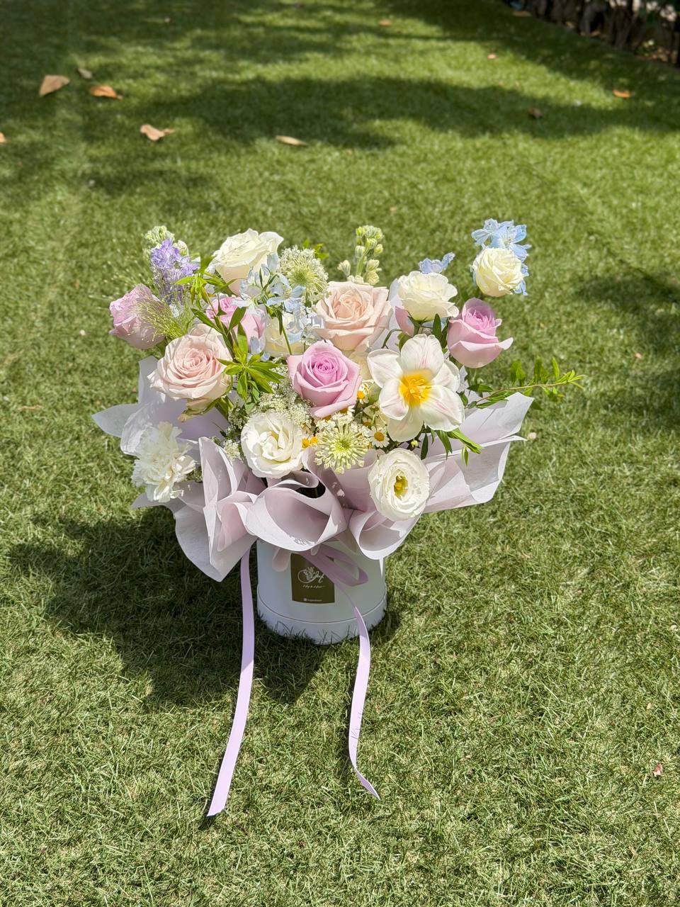 Luxury lilac and white flower box with roses and spring flowers for housewarming gifts.