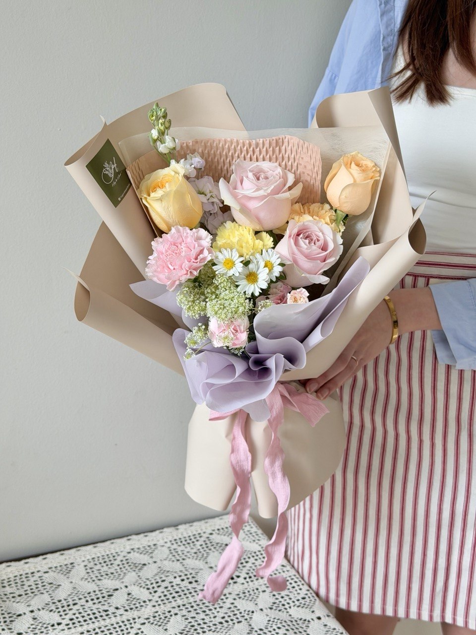 A girl is holding a small bouquet of pastel flower perfect for birthday, anniversaries or just because flower gift.