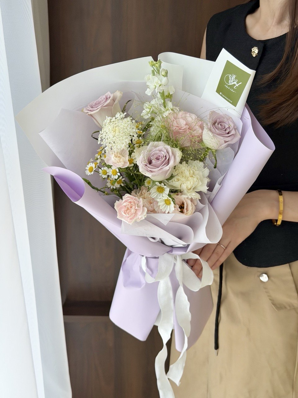 A girl wearing black top is holding a bouquet of purple roses with mixed filler perfect for birthday flower and same day flower delivery at Kuala Lumpur and Selangor.