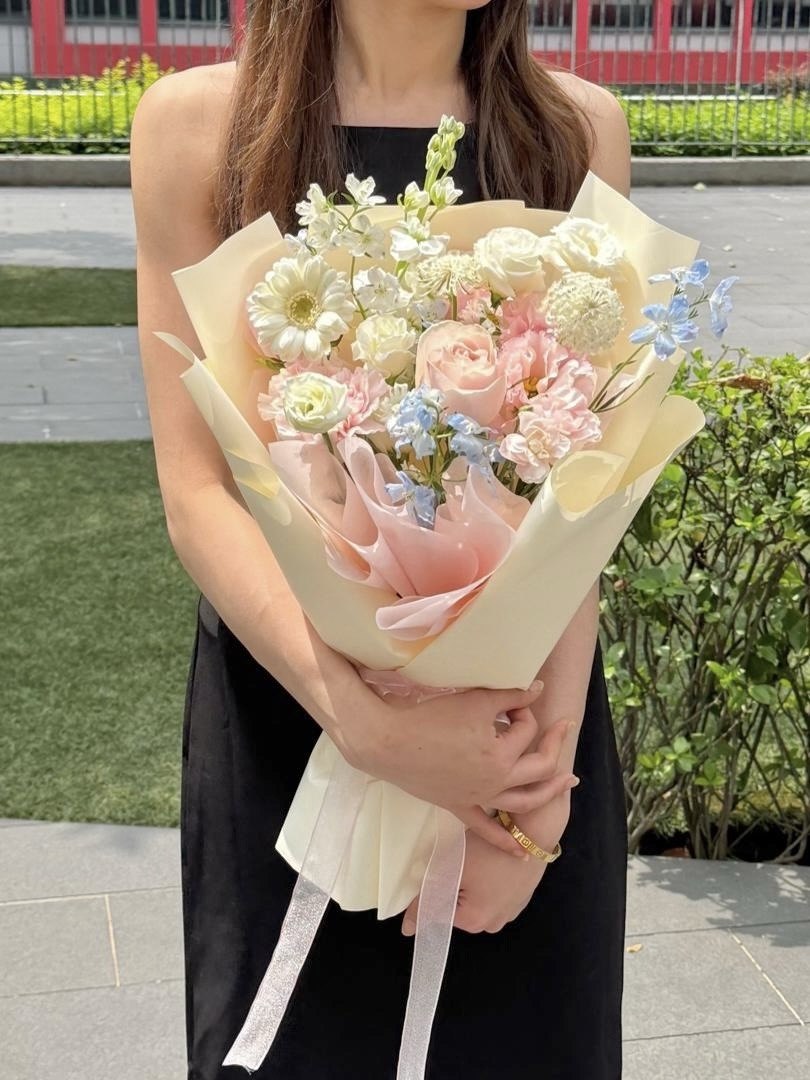 A girl is holding this flower bouquet featuring how to take a picture when holding a flower bouquet.
