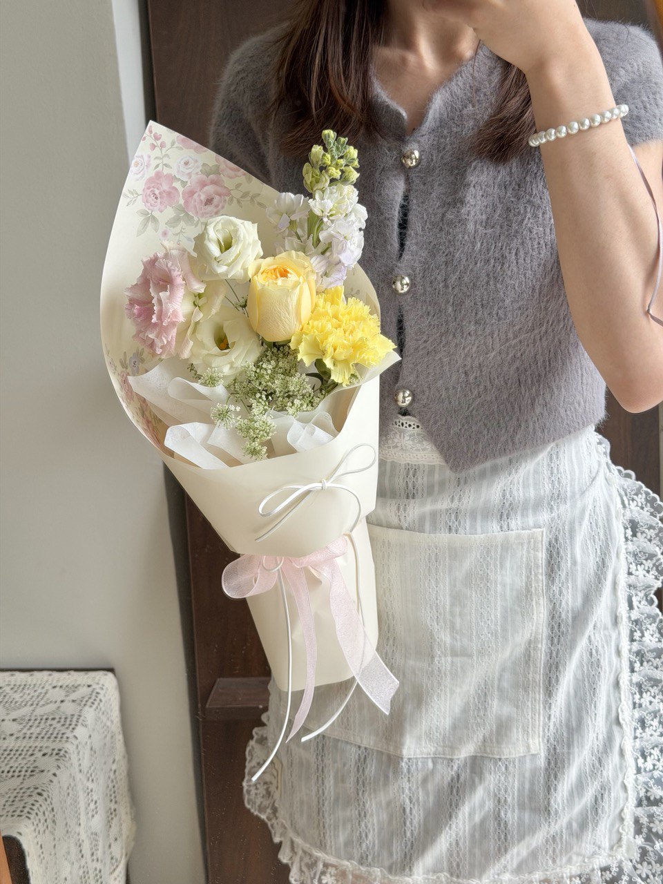 A girl is holding a bouquet of small yellow flower perfect for International Women’s Day 3.8 女神节。