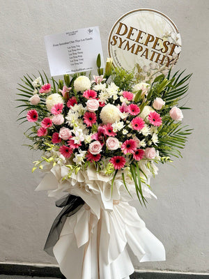 Floral arrangement with pink and white flowers, white ribbon, and 'Deepest Sympathy' sign on a gray background with delivery at Kuala Lumpur and Selangor.