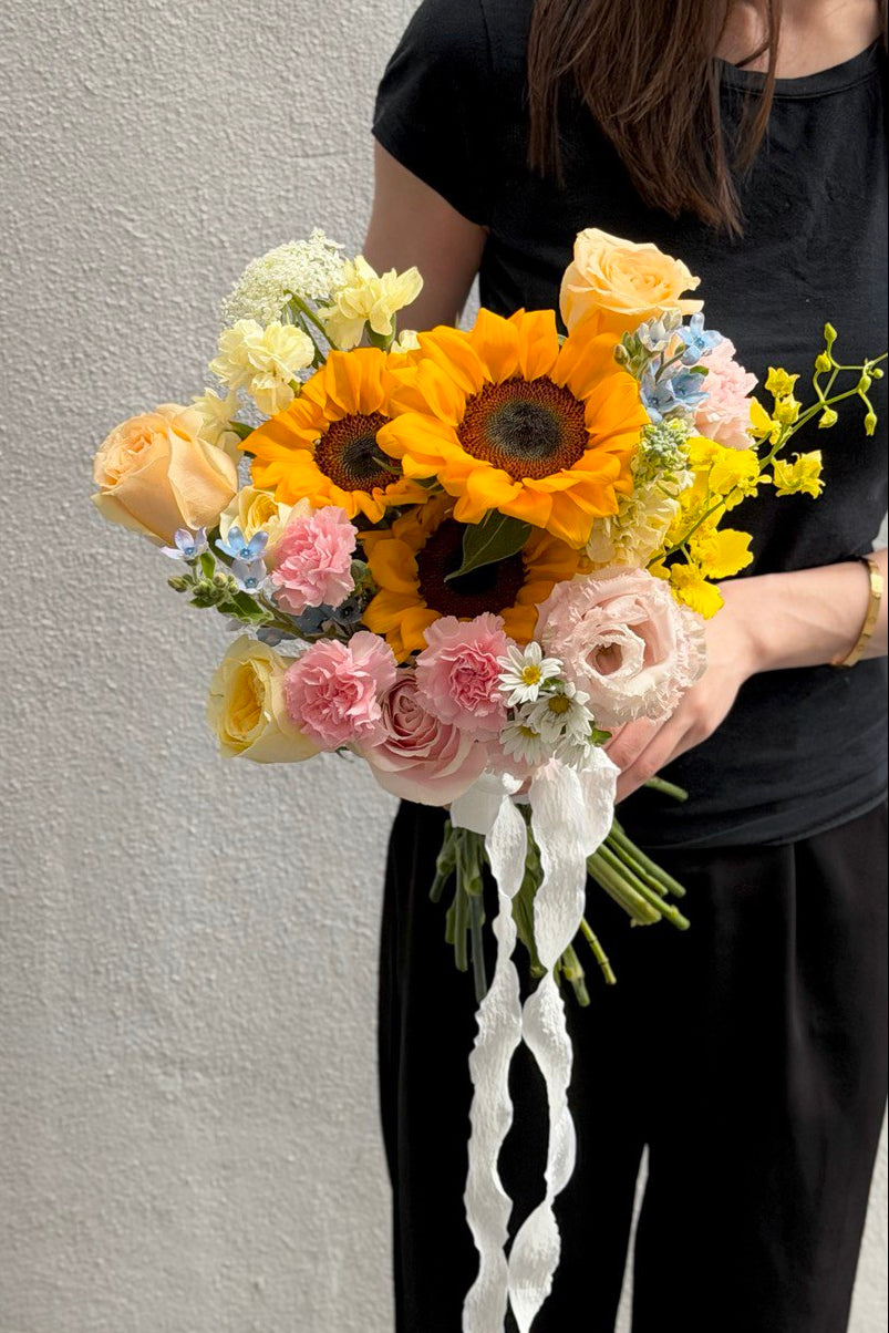 A girl is wearing black holding a bouquet of Sunflower ROM wedding flower with same day delivery at Kuala Lumpur and Selangor.