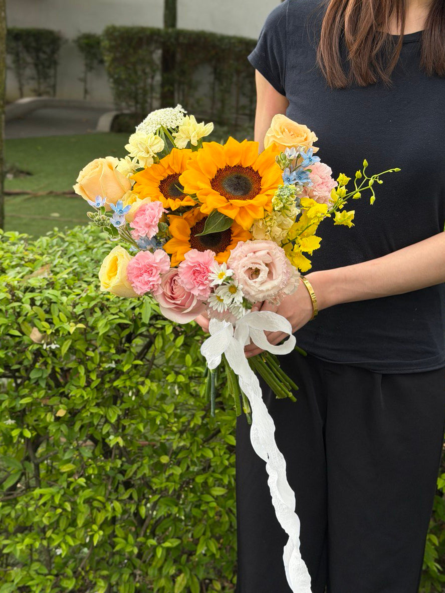 A girl is wearing black holding a bouquet of Sunflower ROM wedding flower with same day delivery at Kuala Lumpur and Selangor.