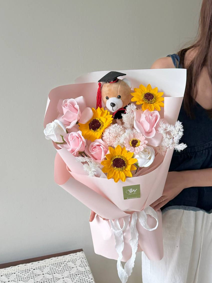 A girl is holding a graduation bouquet featured soap flower with brown graduation bear perfect gift for University graduation at Malaysia.
