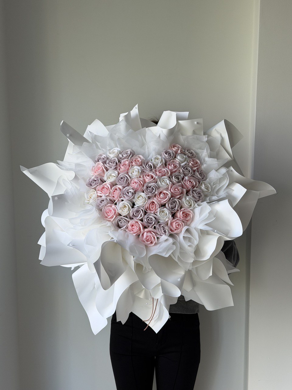 52 rose soap flower heart-shaped arrangement of pink, white and yam soap rose flowers with white ballet wrapper on a plain background - ideal for proposal.

