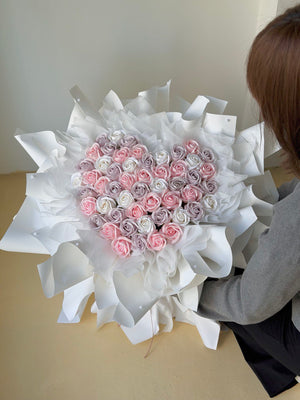 52 roses with heart-shaped bouquet of pink and white soap flowers wrapped in white paper, held by a person at Subang Jaya.