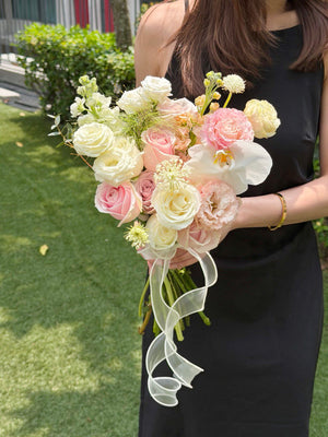 A girl wearing black dress is holding a bouquet of wedding ROM flower consists of pink roses, white roses, white phalaenopsis and some Eustoma with same day delivery at Kuala Lumpur and Selangor.