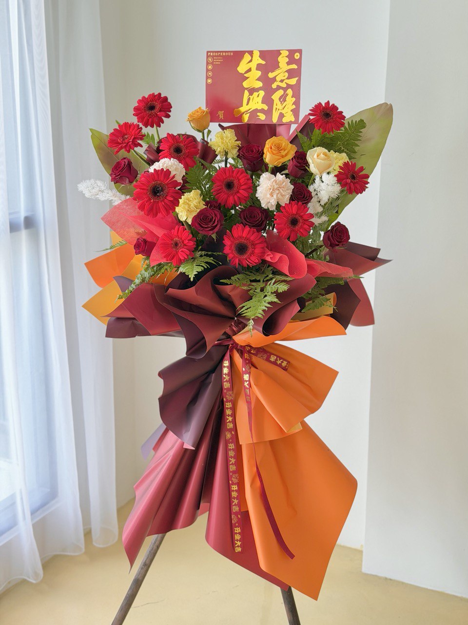 A grand opening flower stand with red gerbera, red roses, carnation and paku leaf - perfect for Grand Opening Flower Stand gift ideal, same-day delivery at Kuala Lumpur and Selangor.