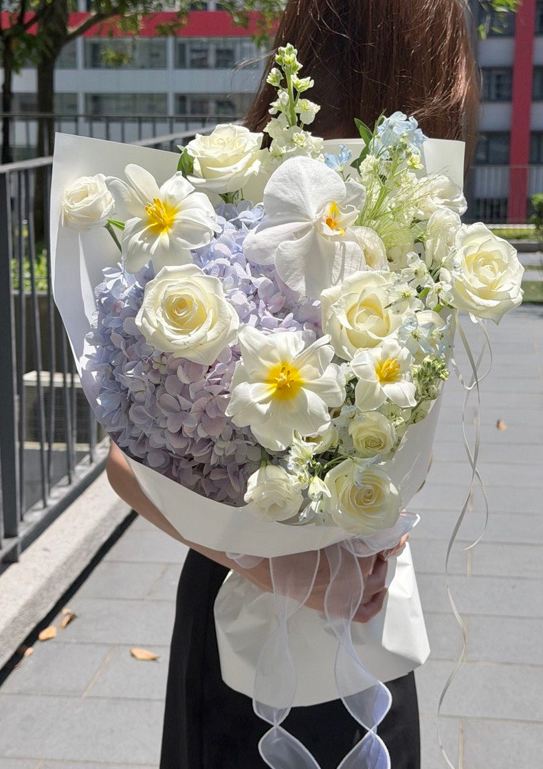 Pastel purple hydrangea bouquet with white rose, tulip and Phalaenopsis orchid.