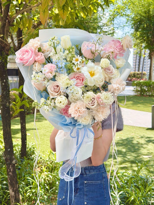 Luxury hand bouquet in blue and pink tones featuring premium pink roses, blue delphinium, white tulip, carnations, and delicate seasonal flowers, available for same-day flower delivery in Kuala Lumpur and Selangor.